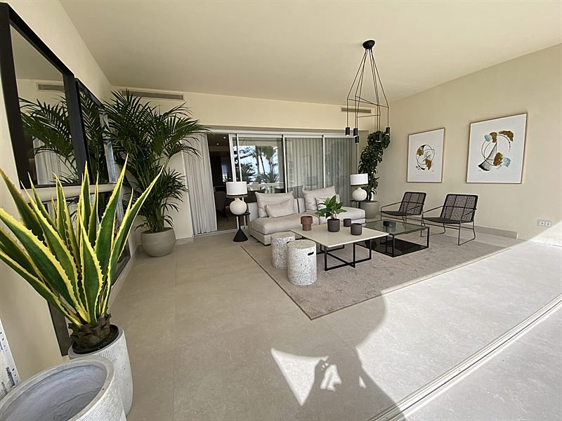 Salón principal con grandes ventanales y vegetación interior