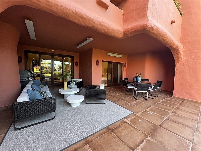 Terraza cubierta con arco de medio punto y zona de estar exterior