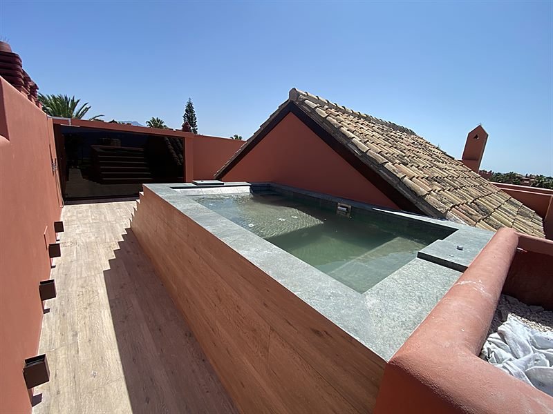 Piscina privada ejecutada sobre la terraza, entre las cubiertas de teja
